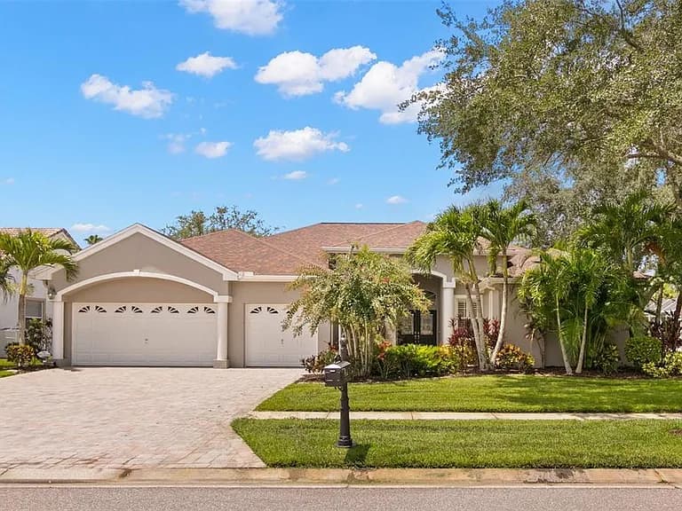 A North Path home with a paver driveway and Florida landscaping